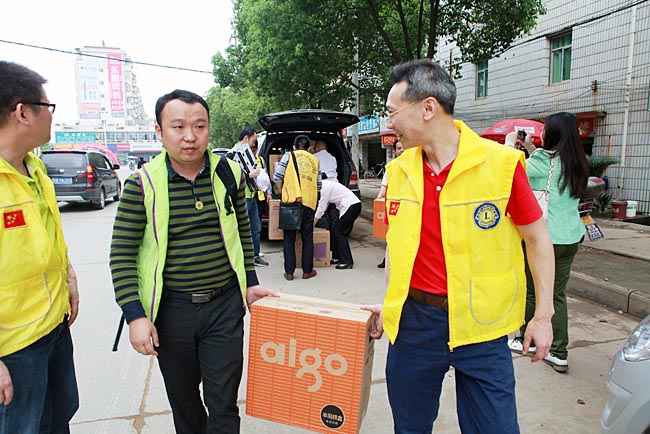 獅兄們將捐贈(zèng)的電腦等物資搬下車